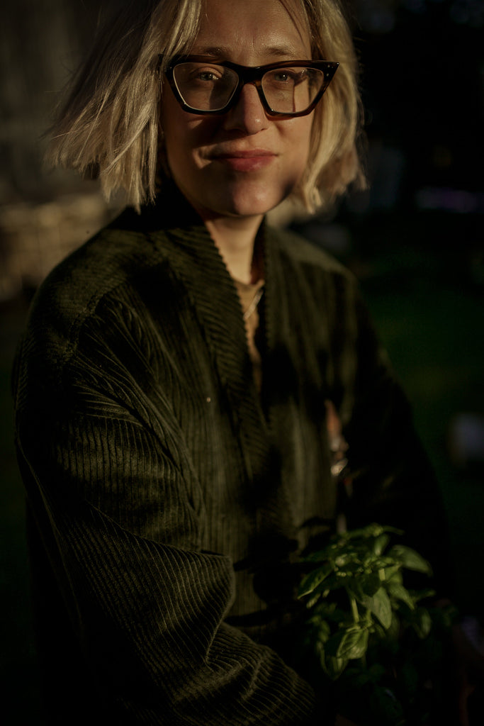 Woman looking to camera wearing glasses and green corduroy garden kimono